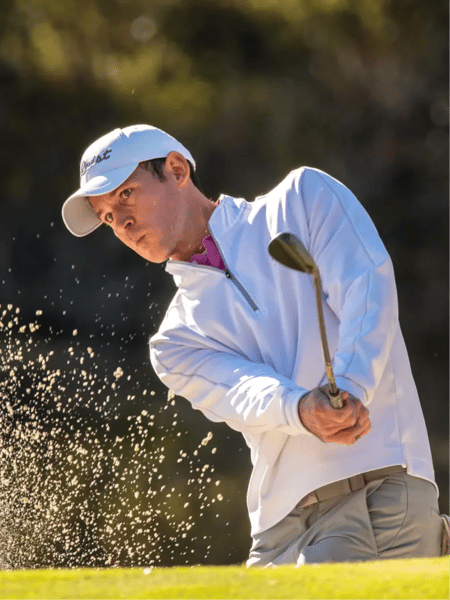 Photo of a golfer chipping the ball out of a sand trap